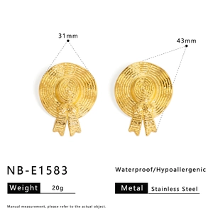 Detail view of gold stainless steel straw hat earrings with woven texture and ribbon
