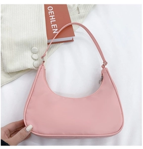 Pink nylon crescent shoulder bag on a white textured background for casual style