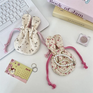 Macro view of cute bunny ear floral drawstring bags for cosmetics on a stylish desk setup