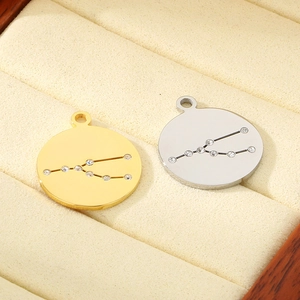 18K gold and silver stainless steel zodiac charms with crystals on jewelry cushion