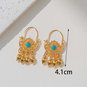 Detailed view of 18K gold bohemian earring with blue stone and teardrop charms