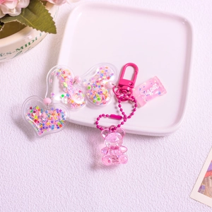 Rosa Acryl-Bär Schlüsselanhänger mit Glitzerherz und Sweet-Candy-Anhänger auf Tablett
