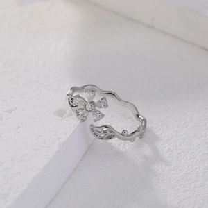 Detailed macro view of silver flower zircon ring with wavy texture on white stone