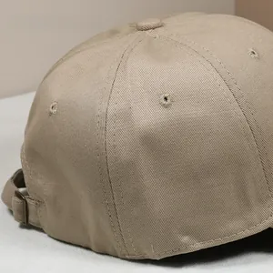 Close-up of khaki cotton baseball cap back with adjustable metal buckle and eyelets