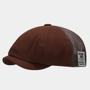 Detail of coffee newsboy cap featuring breathable mesh panels and vintage woven side label