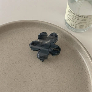 Détail de la pince à cheveux fleur avec texture marbrée gris foncé et texte doré fait main