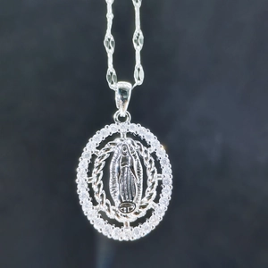 Detailed macro view of silver Virgin Mary pendant with sparkling white cubic zirconia inlay