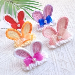 Detailed shot of five colorful hand-knitted bunny ear hair clips with pearls and bows