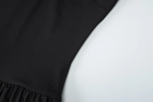 Detailansicht der schwarzen Jerseystoff-Textur mit feinen Falten und Rüschensaum