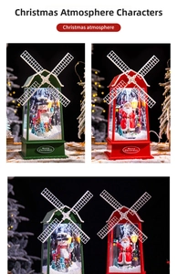 Gros plan d'une lanterne de Noël avec moulin à vent, Père Noël et décor de neige