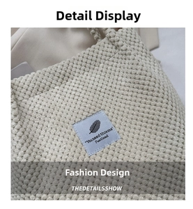 Macro shot of textured bubble fabric on beige tote bag with blue decorative label