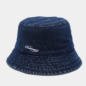 Detailed view of white uuloan embroidery on dark blue washed denim bucket hat material