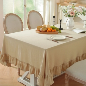 Beige washed cotton tablecloth with elegant ruffled pleated edges for a home dining set