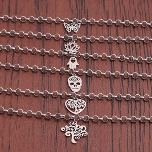 Sleek stainless steel bracelet set with lotus and hamsa charms on dark leather