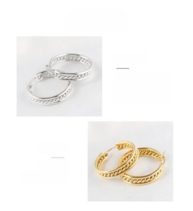 Detailed view of large gold and silver hoop earrings with spiral twisted texture