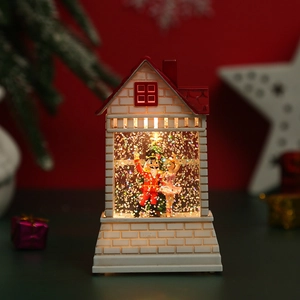 Detail of Nutcracker and ballerina inside a glowing Christmas house lantern lamp