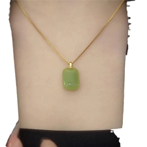Elegant gold necklace featuring a rectangular green jade pendant on model neck
