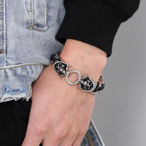 Close-up of punk style skull bracelet with black braided leather and silver steel