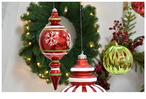 Detail of red snowflake glass ornaments and green striped bulbs on a festive wreath