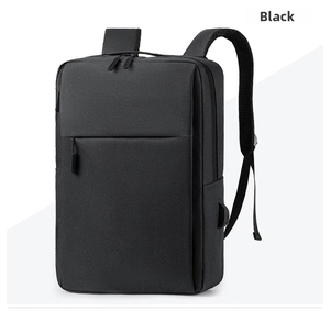 Detail of minimalist black backpack featuring external USB charging port and waterproof fabric