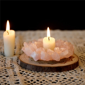 Nahaufnahme des rosa Kristallkerzenhalters auf Holzsockel mit warmem Kerzenlicht-Ambiente