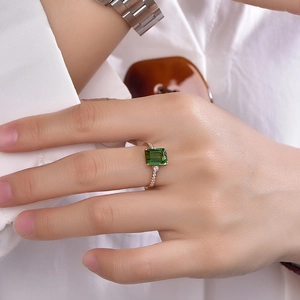 Emerald cut green tourmaline ring in 18K rose gold with pavé diamonds on model hand