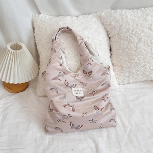 Detail of satin shoulder bag featuring jacquard butterfly patterns and woven brand label
