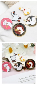 Detail of funny enamel pins featuring cartoon geese and creative gulls on white canvas