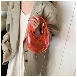 Pink transparent acrylic evening bag with gold chain strap shown in horseshoe shape