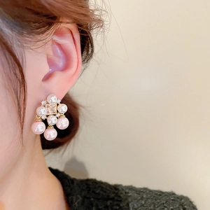 Close-up of vintage gold-plated square zircon earrings with pearl tassels on ear