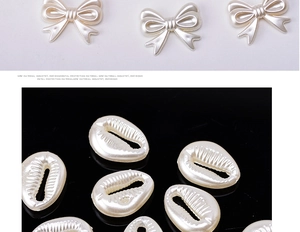Detailed view of cream white resin bow and shell shaped beads with pearl luster finish