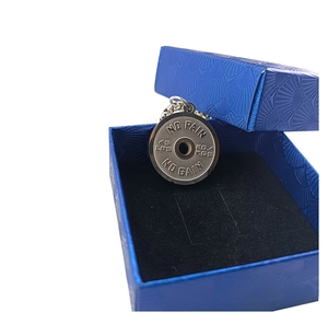 Macro shot of stainless steel barbell pendant with motivational text in a blue gift box