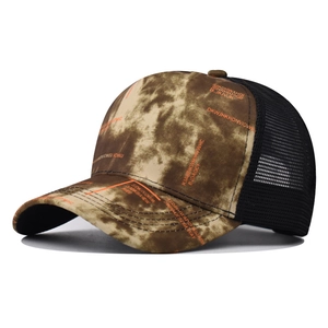 Detail of gradient tie-dye trucker hat with orange lettering and black breathable mesh back