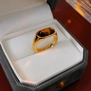Detail of vintage gold-plated ring with oval tiger eye stone in a velvet jewelry box