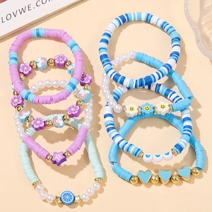 Close-up of 8-piece bohemian beaded bracelet set featuring colorful clay discs and charms