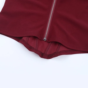 Detail of red lace corset top showing metal zipper closure and high-quality stitching