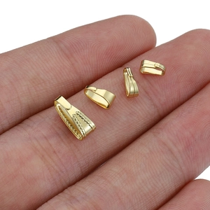 Set of four gold stainless steel jewelry bails in various sizes shown on a finger