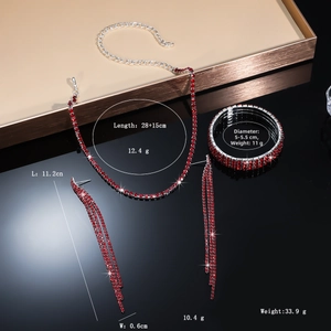 Close-up of red rhinestone jewelry set featuring tassel earrings and claw chain necklace
