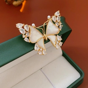 Detailed close-up of 18k gold-plated butterfly brooch with pearl and zircon inlay