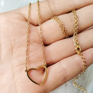 Detailed close-up of a hollow heart pendant necklace in gold-plated stainless steel