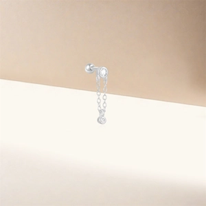 Macro view of silver S925 earrings with thin chains and sparkling white zircon accents