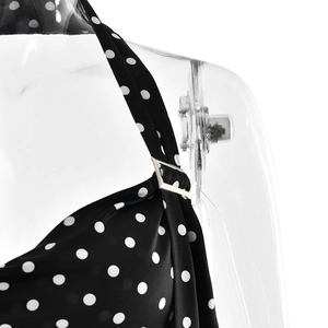 Détail du tissu à pois noirs avec anneau métallique sur un haut à bretelles col en V
