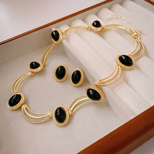 Vintage gold necklace and earring set with black oval stones in a luxury gift box