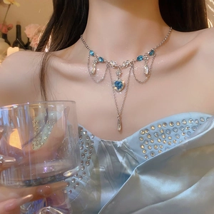 Close-up of bohemian butterfly tassel necklace with blue heart crystal and silver chains