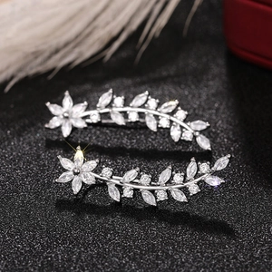 Detail of silver flower ear climbers with sparkling marquise-cut zircons on black background