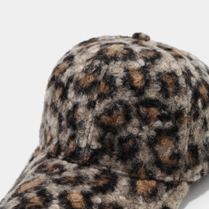 Close-up of thick leopard print sherpa fabric texture on a winter baseball cap