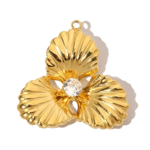 Detail of a vintage gold flower pendant with three petals and a sparkling zircon center