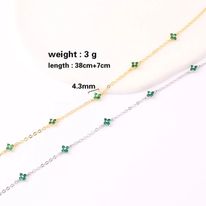Minimalist gold and silver necklaces with green four-leaf flower pendants and chain details