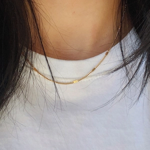 Close-up of minimalist 18k gold plated titanium steel chain necklace on a model