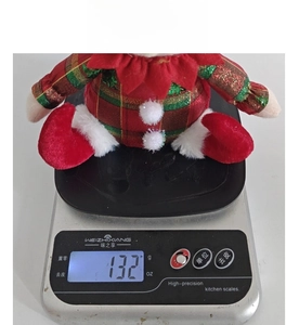 Detailed view of the Christmas elf plush weight being measured on a digital scale